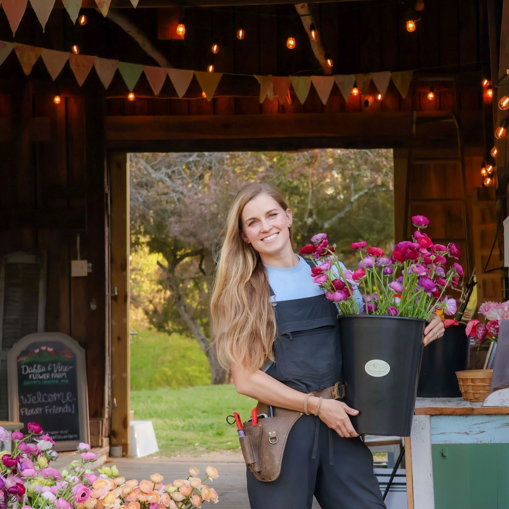woman holding flowers in front of barn